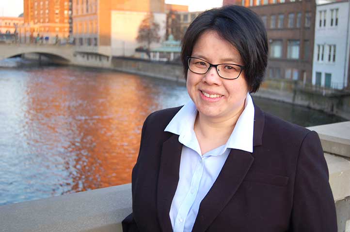 woman with black hair wearing glasses and suit on bridge